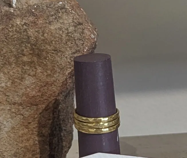 A stack of thin brass rings on a dark ring stand