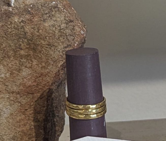 A stack of thin brass rings on a dark ring stand