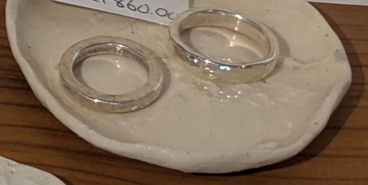Two fine silver bands on a white ceramic dish