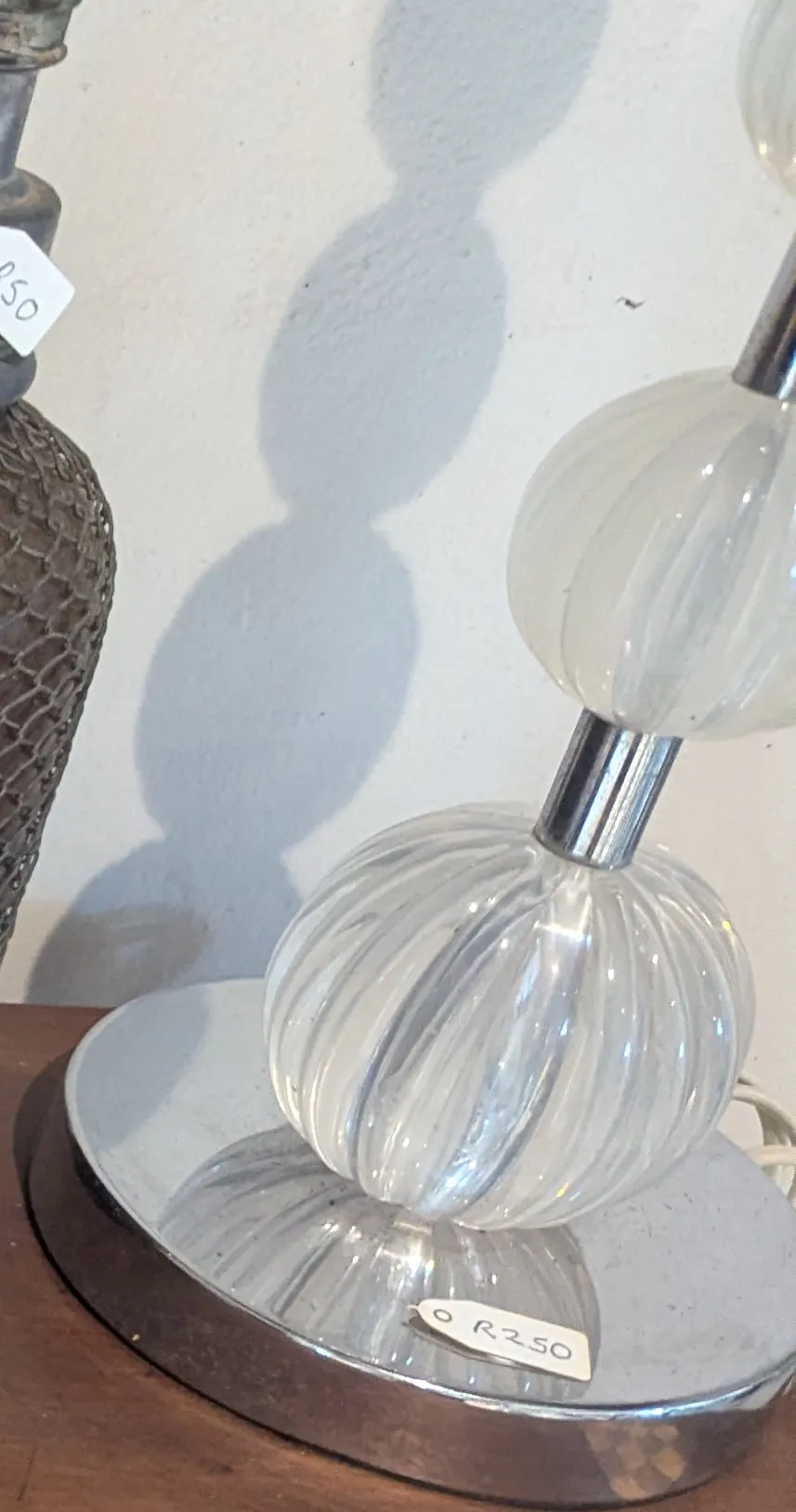 A lamp base of stacked clear ribbed glass globes on a chrome foot