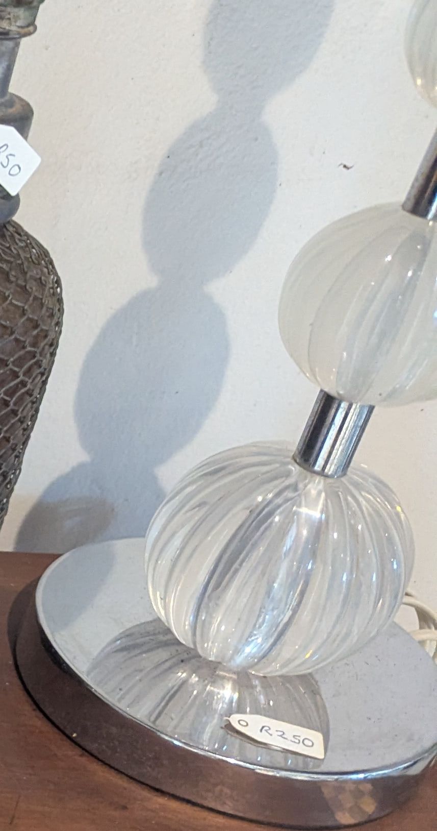 A lamp base of stacked clear ribbed glass globes on a chrome foot
