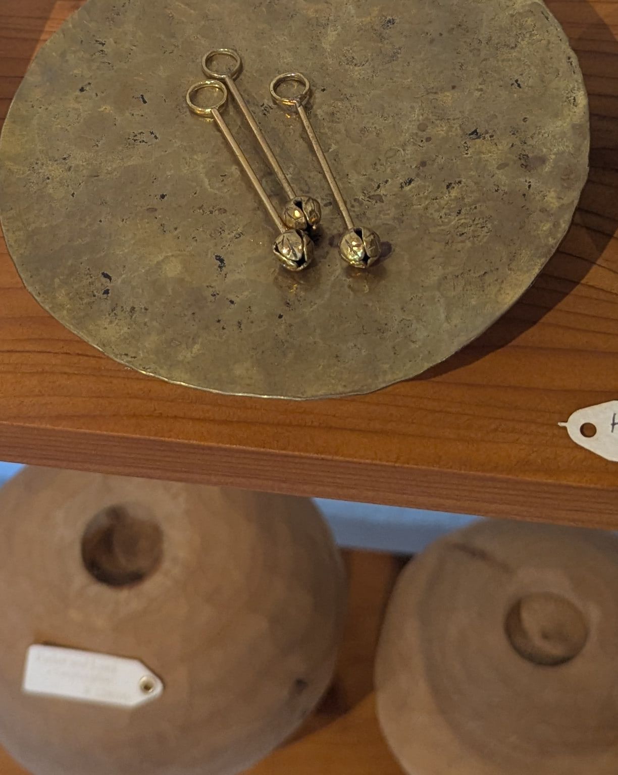 Brass pendants with bud-shaped bells on a hammered brass plate