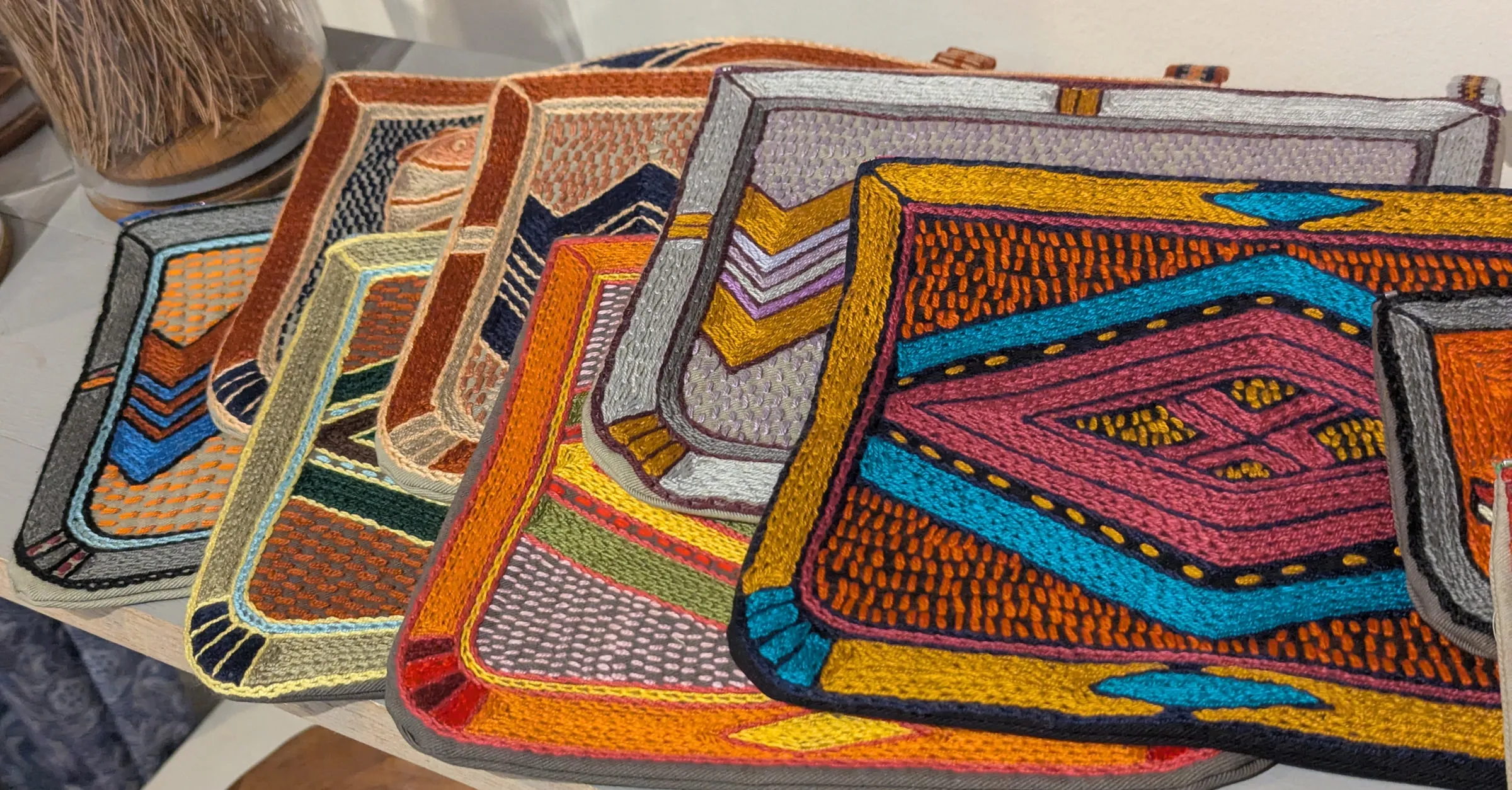 Large Kaross bags embroidered in orange, pink, turquoise and gold geometric patterns