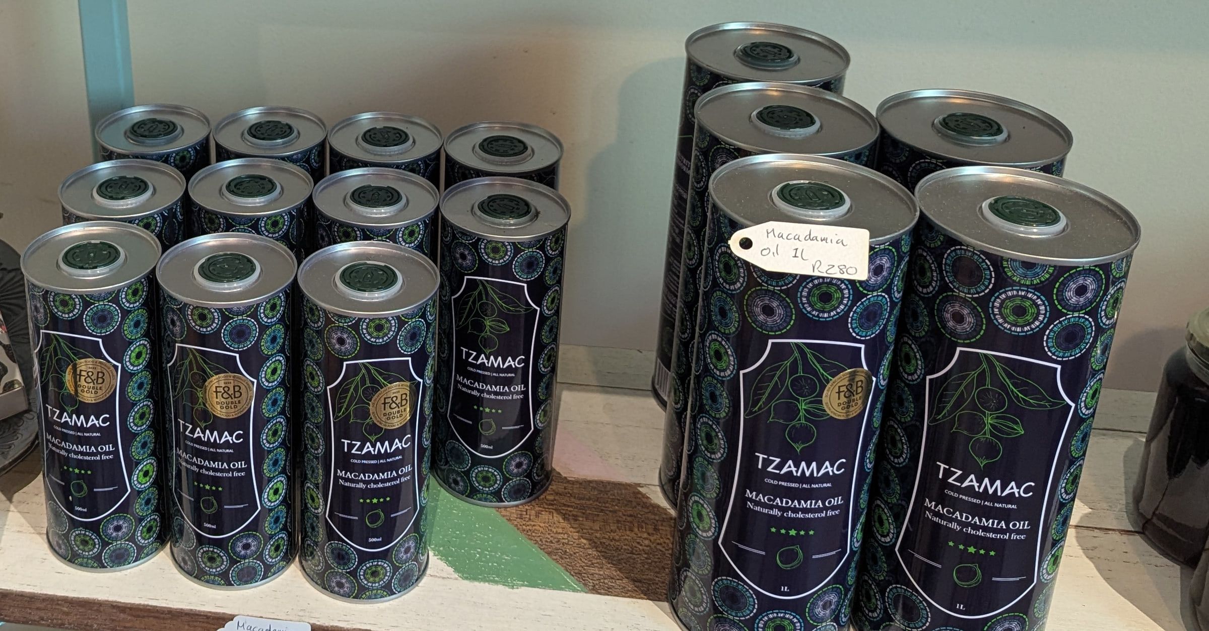 Navy TZAMAC macadamia oil tins with a botanical pattern in two sizes