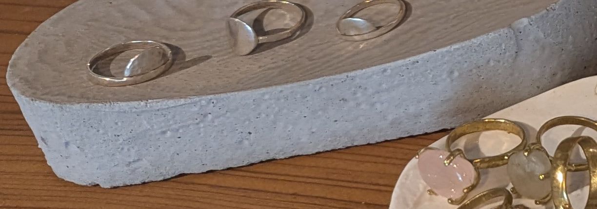 Sterling silver rings on a cast concrete dish