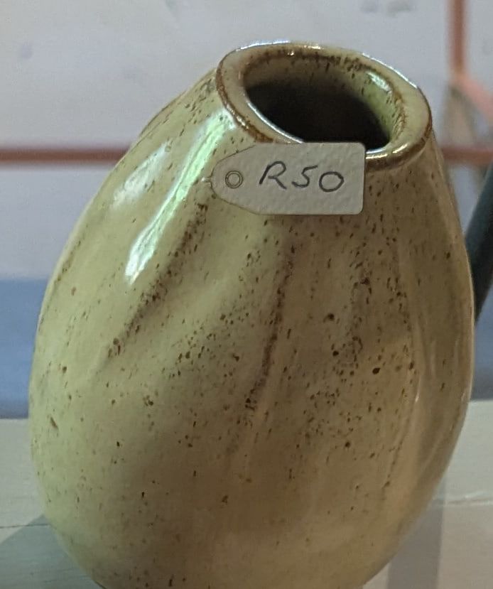 An egg-shaped stoneware vase in pale green speckled glaze