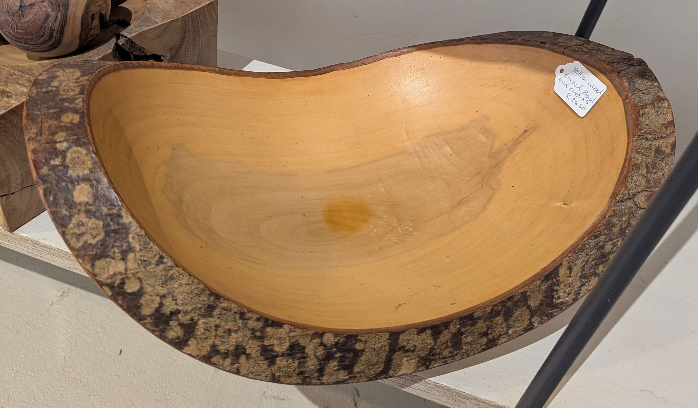 A large yellowwood bowl with natural bark rim and smooth golden interior